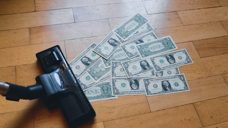 a pile of money sitting on top of a wooden floor